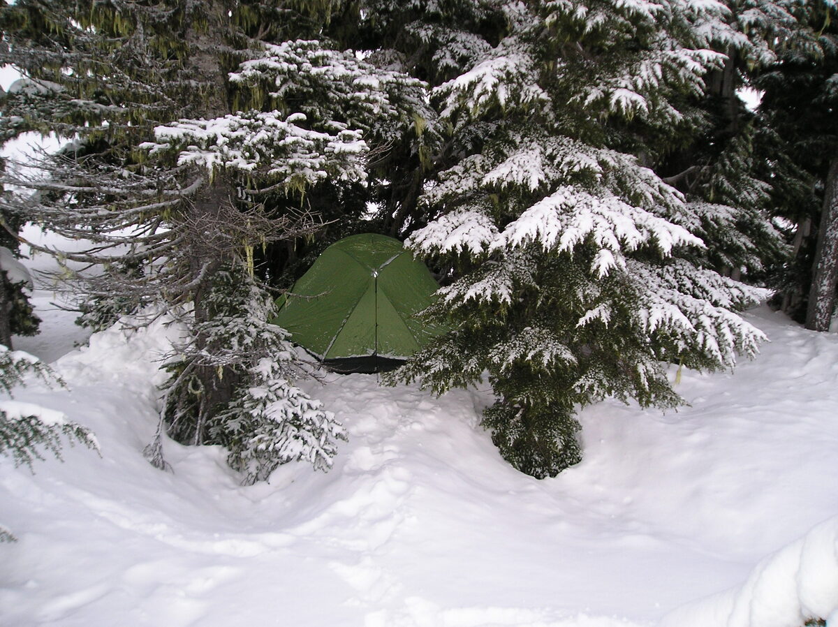 Tent met sneeuw op de ondergrond tijdens winter backcountry camping